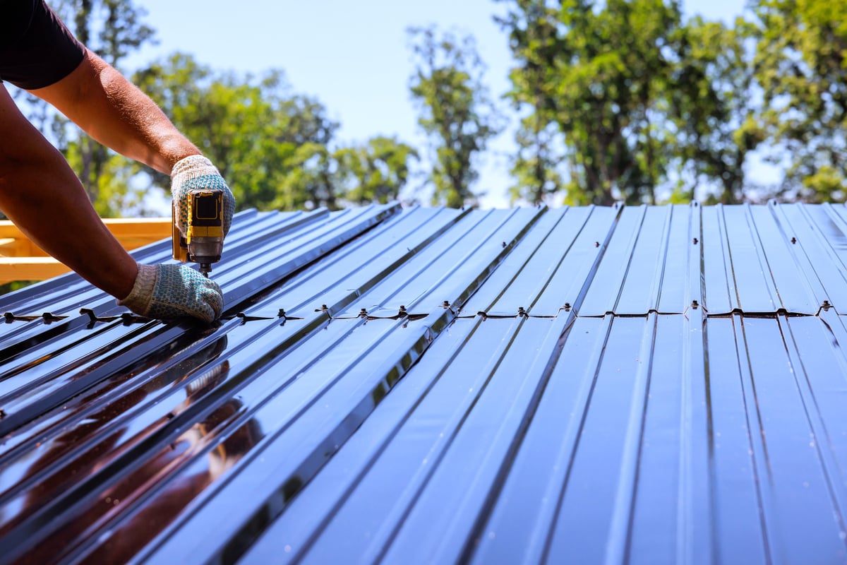 Metal roofing installation — metal roofing sheets being secured