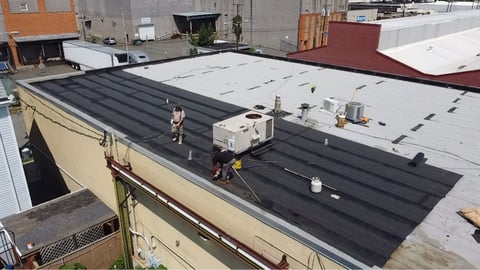 Commercial flat roof membrane installation in progress