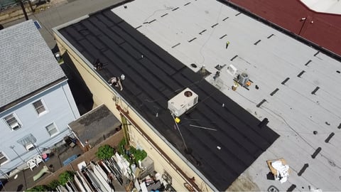 Commercial flat roof membrane installation in progress